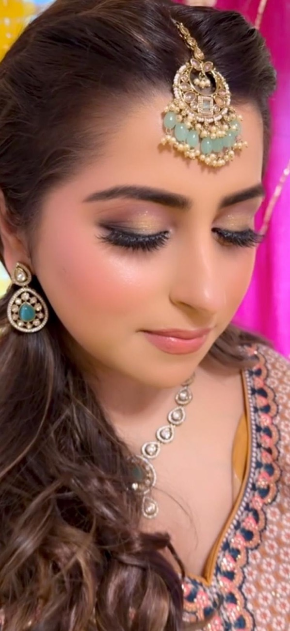 Soft bridal glam with gold tikka and dewy skin by Makeup by Nidari, Houston