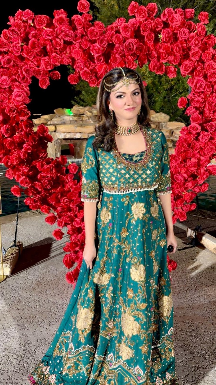 Event glam with teal lehenga at a red rose floral arch by Makeup by Nidari