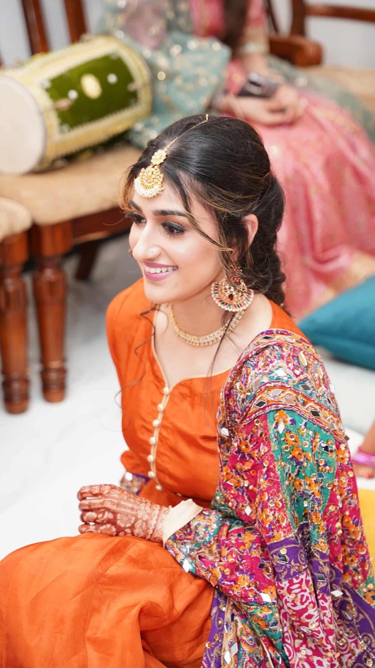 Mehndi event glam in orange with gold jhumka by Makeup by Nidari