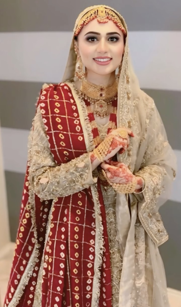 Traditional red bridal look with gold jewelry by Makeup by Nidari